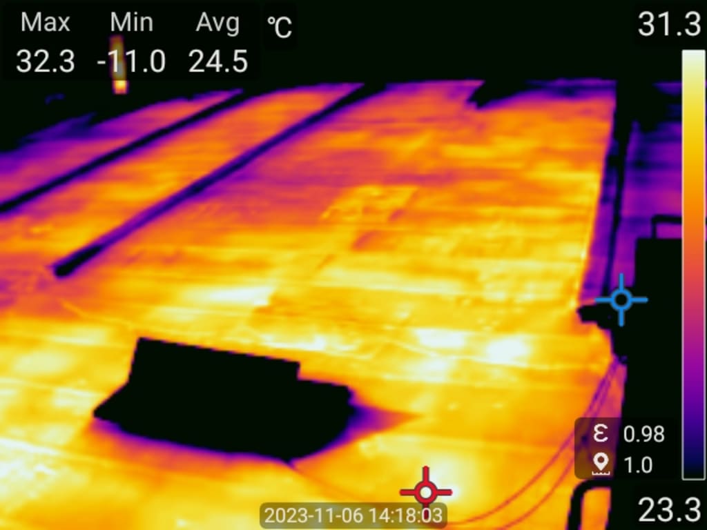 Thermal imaging of a surface with temperature readings displayed.